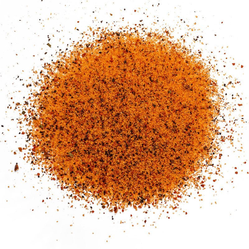 A close-up image of EAT Barbecue Sweetness rub granules, showing a mix of orange and black specks of seasoning.