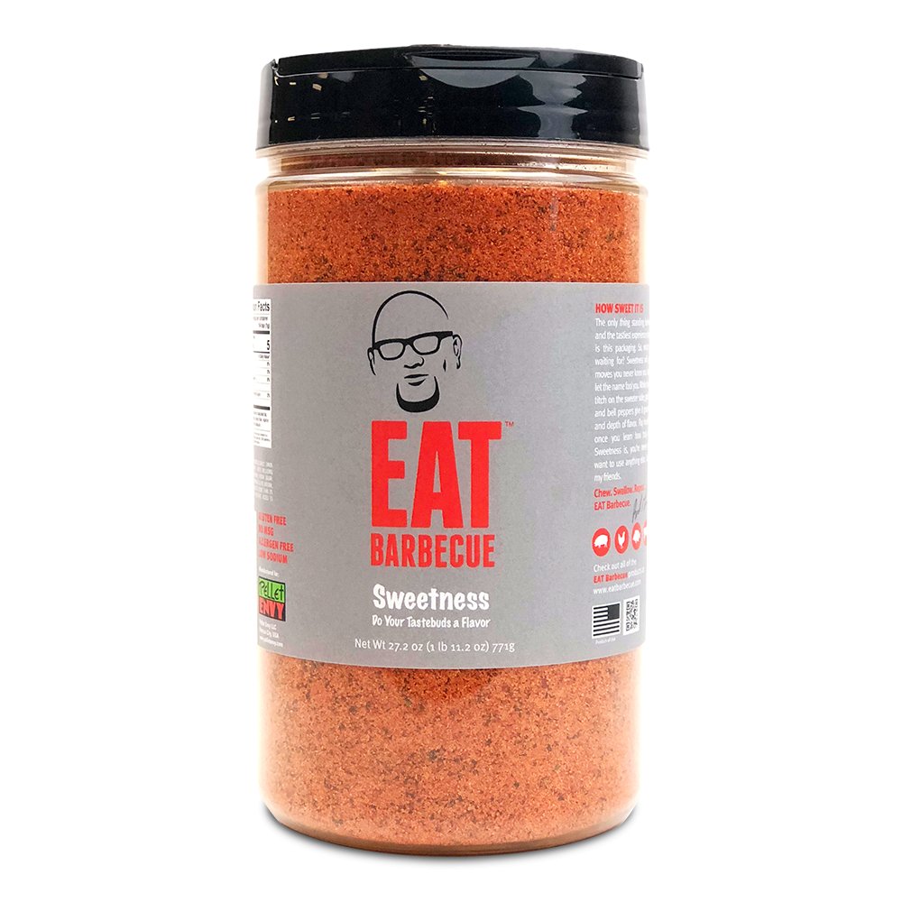 A large container of Eat Barbecue Sweetness Rub with a gray label, black lid, and a net weight of 27.2 oz (771g). The label features a caricature of a man with glasses and the text 'EAT Barbecue Sweetness, Do Your Tastebuds a Flavor.'nces (187 grams).