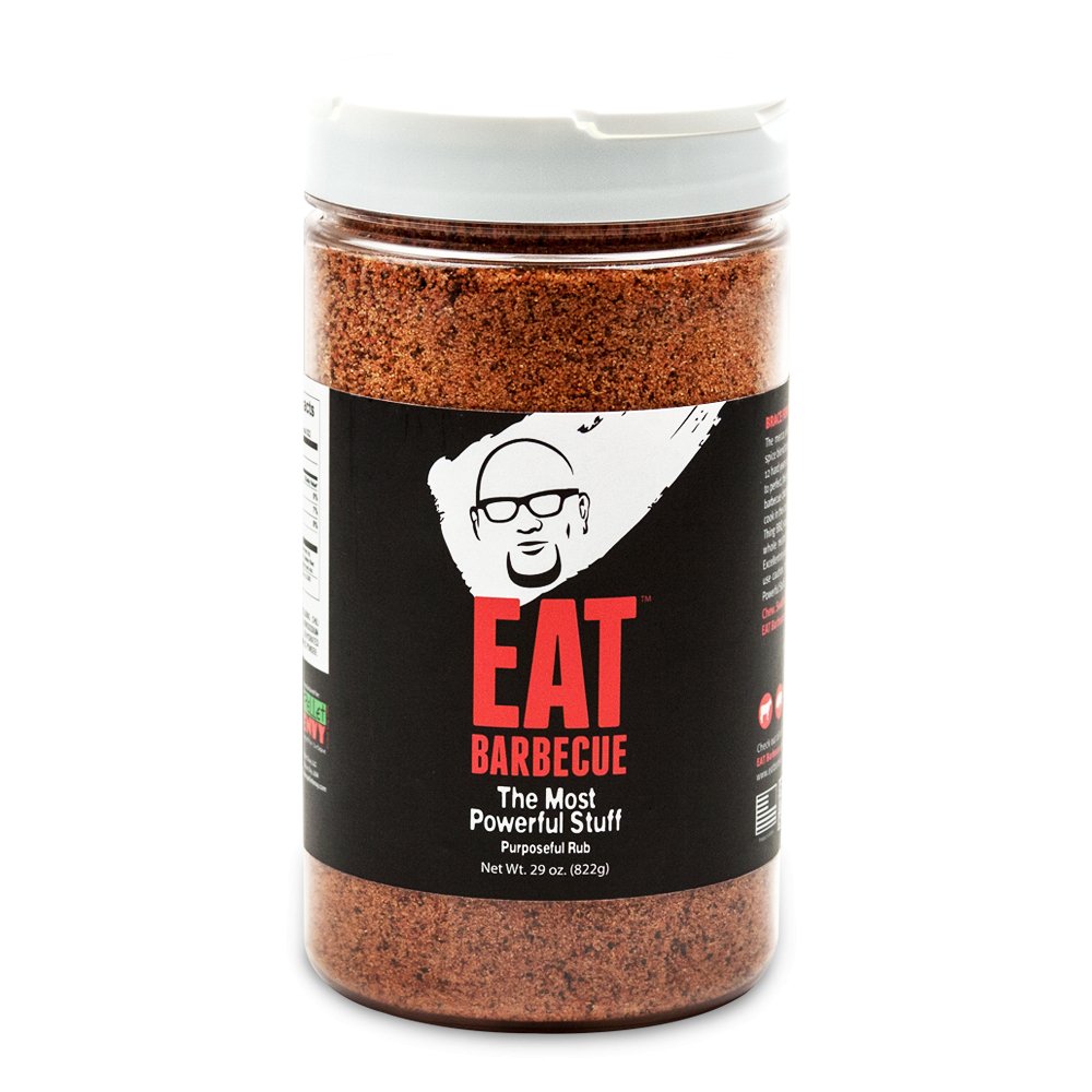 A large plastic jar of EAT Barbecue "The Most Powerful Stuff" BBQ rub, with a white lid and a black label. The label features a white and red logo of a man's face with glasses, and the text "EAT Barbecue" in bold red letters. The jar contains 29 ounces (1 lb 13 oz) of the seasoning.