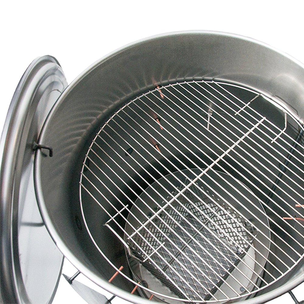 Top view inside of a glossy drum smoker showing the grilling grate and charcoal basket.