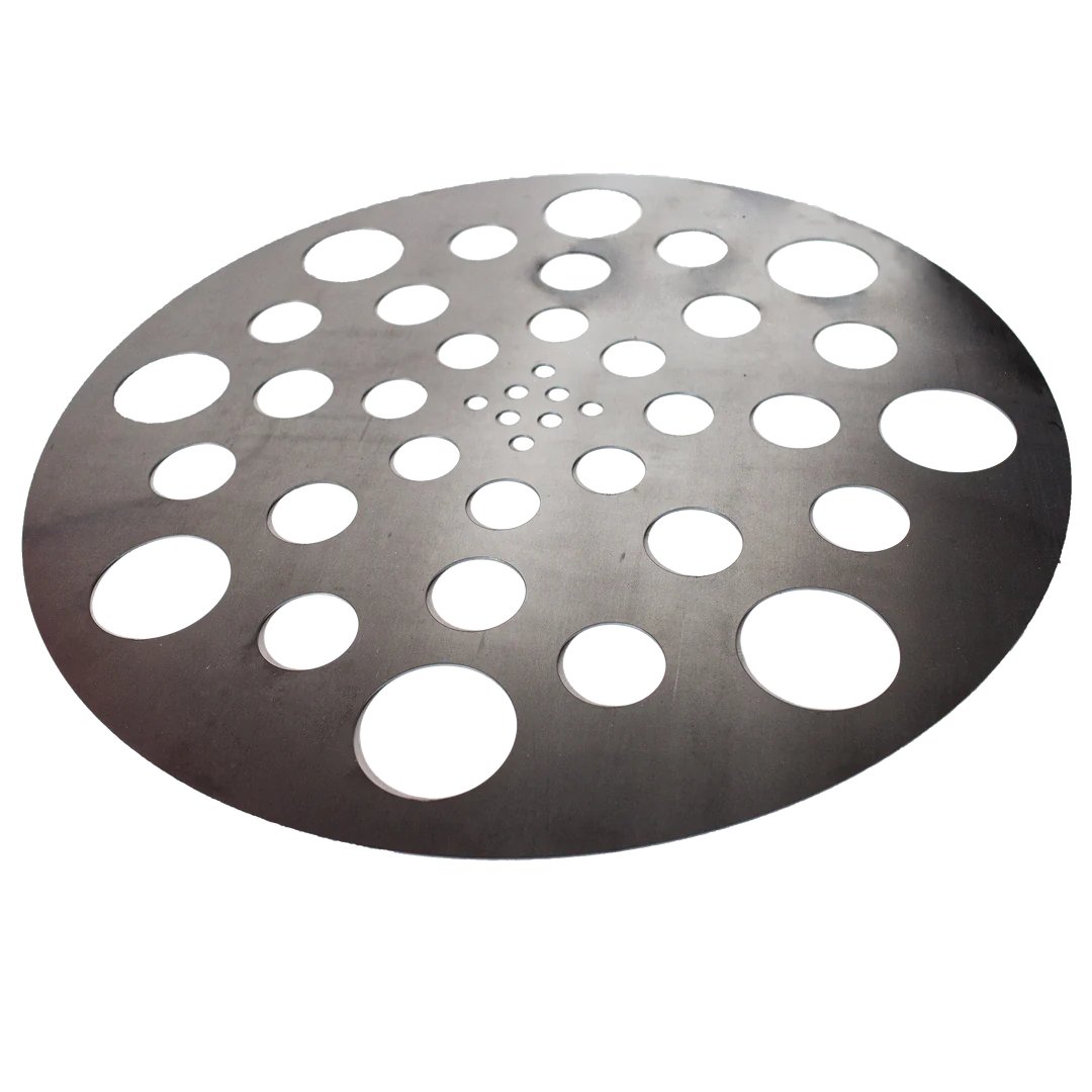 A circular metal diffuser plate with multiple holes of varying sizes arranged in a pattern, used for heat distribution in a drum smoker.