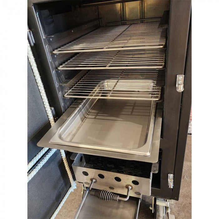 The interior of a BBQ smoker with multiple metal racks, a drip pan, and a charcoal drawer, with the door open.