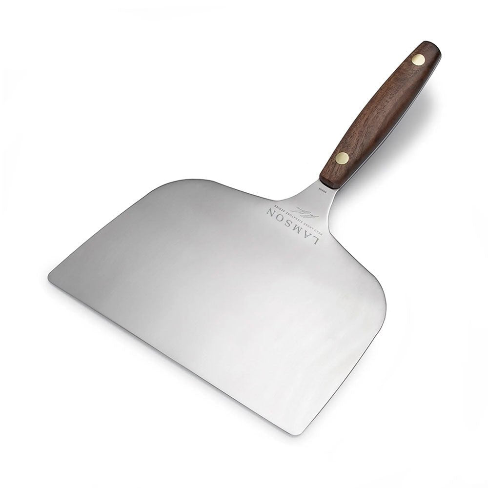 A large Lamson griddle turner with a wide stainless steel blade and a wooden handle featuring two brass rivets. The turner is shown against a white background, showcasing its ample surface area for flipping and turning food.