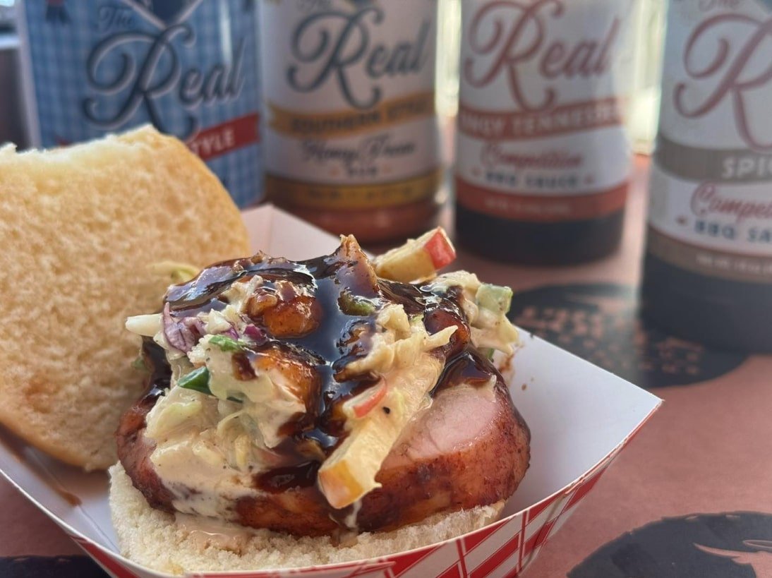 Pork tenderloin sandwich with slaw and topped with Man Meat's BBQ Sauce