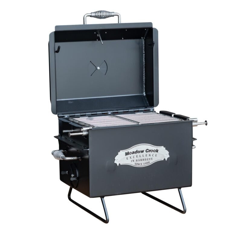 Angled view of the Meadow Creek BBQ18 Chicken Cooker with the lid open, revealing the cooking grate. The cooker features a "Meadow Creek Excellence in Barbecue Since 1980" logo on the front.