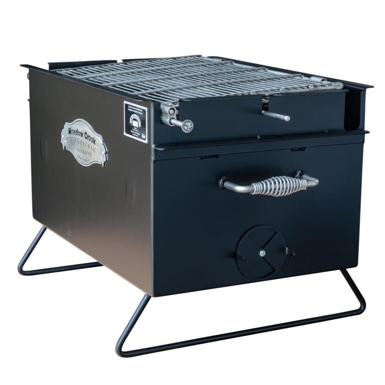 Side view of the Meadow Creek BBQ26 Chicken Cooker with the lid open, showing the cooking grate. The cooker has sturdy handles and a classic design with the Meadow Creek logo.