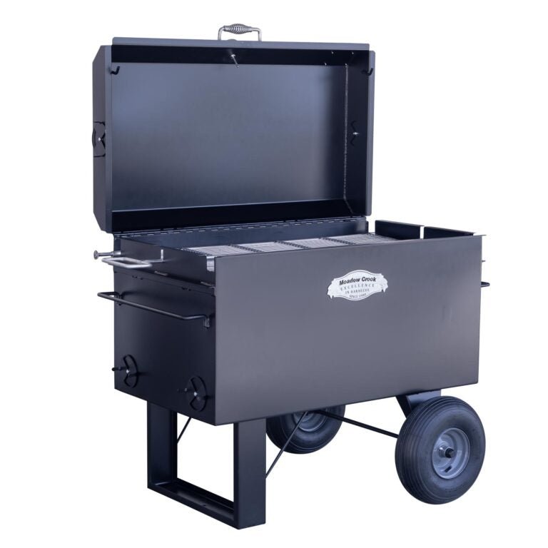 Front view of the Meadow Creek BBQ42 Chicken Cooker with the lid open, showing the stainless steel grate inside. The cooker features a large cooking area and the Meadow Creek branding on the front.