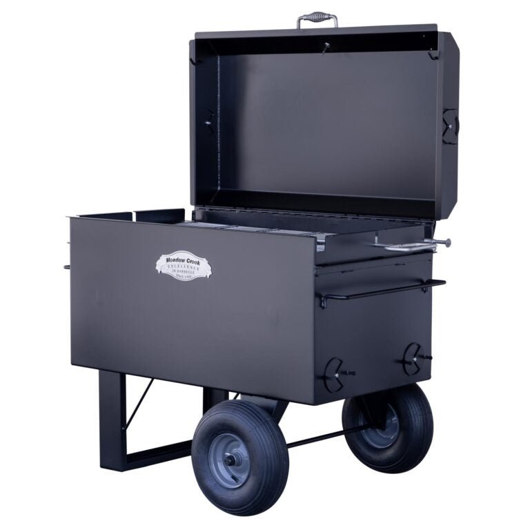 Angled view of the Meadow Creek BBQ42 Chicken Cooker with the lid open. The cooker has a temperature gauge on the lid and a robust design with large tires for easy transport.