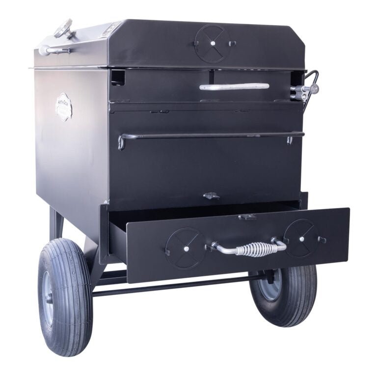 Angled view of the Meadow Creek BBQ42 Chicken Cooker with the charcoal pullout tray extended. The cooker is mounted on large wheels, making it easy to transport.