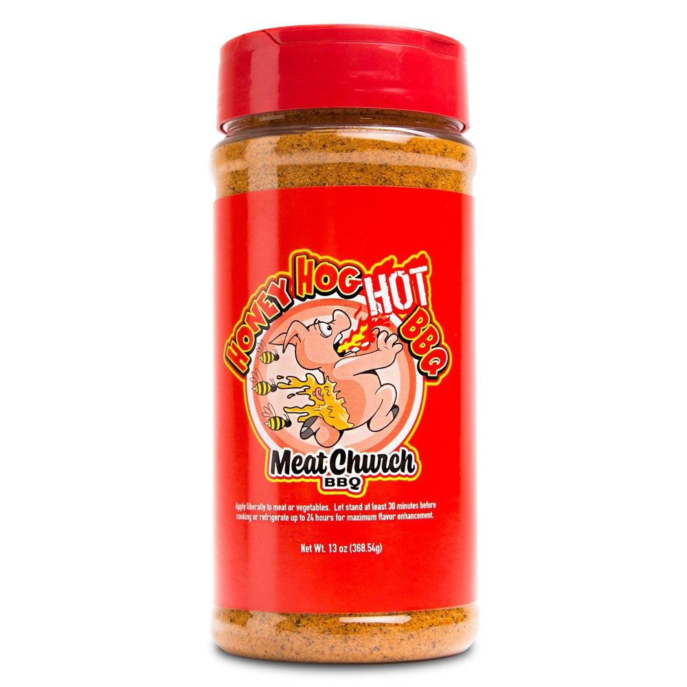 A 13-ounce jar of Meat Church Honey Hog Hot BBQ Rub. The label is red with yellow and white text, featuring a cartoon pig breathing fire, surrounded by bees. The jar has a red lid and contains a coarse, reddish-brown spice mix.