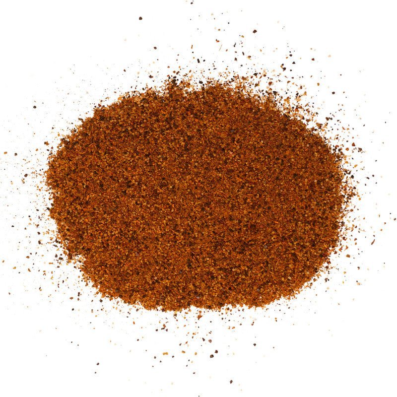 A close-up view of a pile of Meat Church Texas Chili Seasoning. The spice mix is a coarse, dark red powder with a fine, consistent texture.