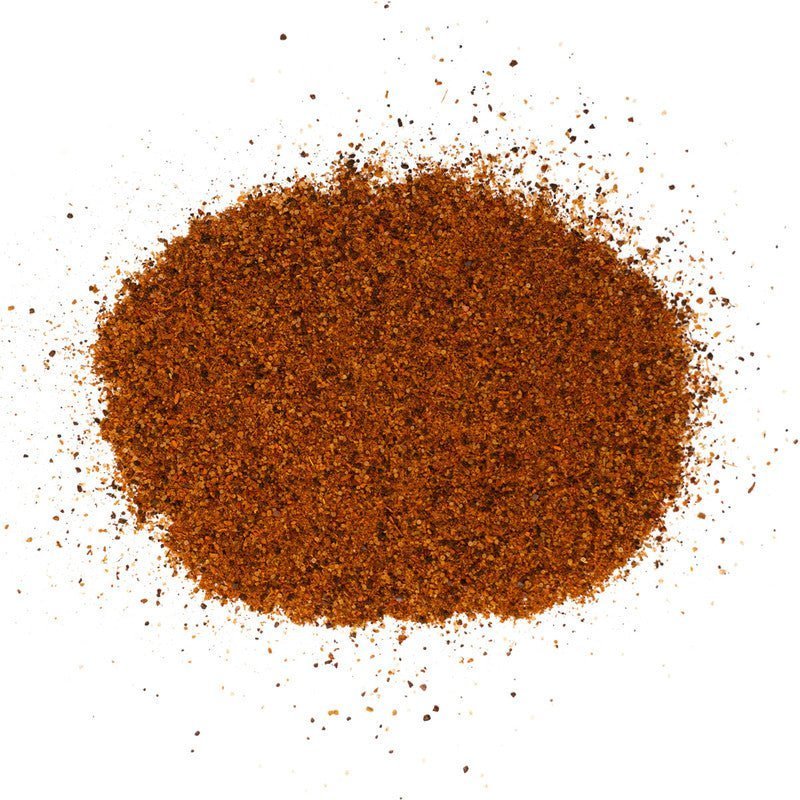 A close-up view of a pile of Meat Church Texas Chili Seasoning. The spice mix is a coarse, dark red powder with a fine, consistent texture.