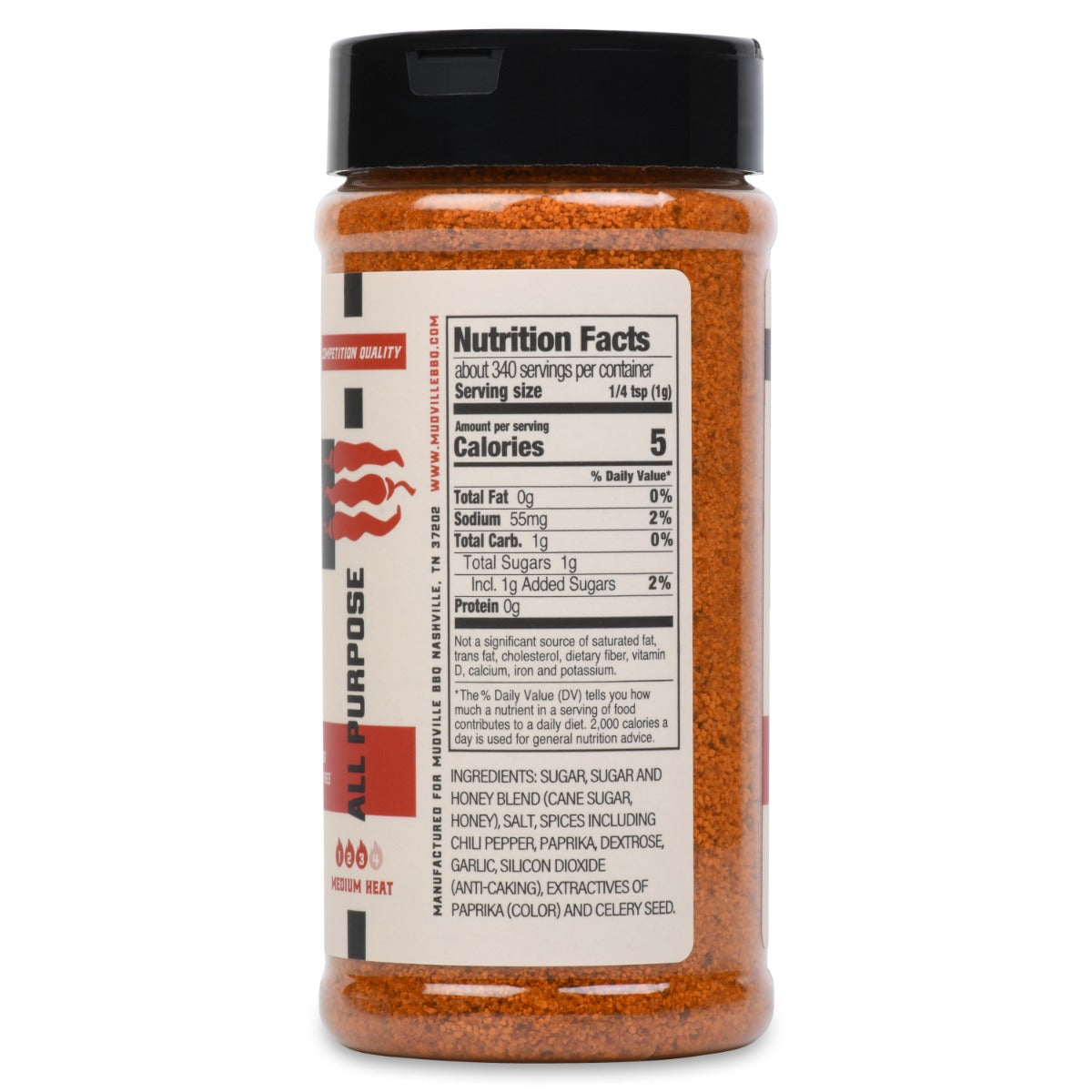 Side view of a bottle of Mudville BBQ Prime Heat All Purpose Rub showing the nutrition facts. The label details the serving size, calories, total fat, sodium, total carbohydrate, total sugars, and protein content. It also lists the ingredients, which include sugar, honey blend, salt, spices like chili pepper and paprika, and anti-caking agents.