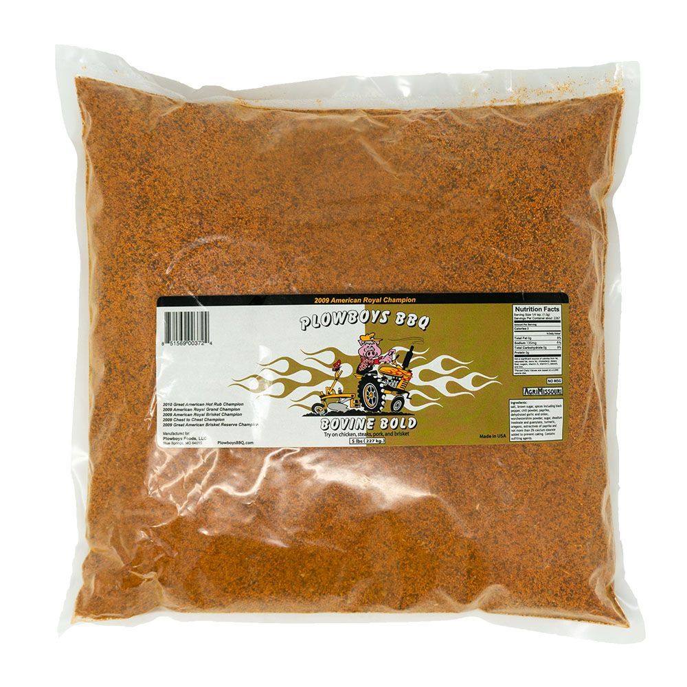 A sealed, transparent plastic bag containing 5 pounds of Plowboys BBQ Bovine Bold Rub. The bag features a label with the product name, "Plowboys BBQ Bovine Bold," and a colorful illustration of a pink pig driving a tractor with flames in the background. The label also highlights that this rub is the 2009 American Royal Champion. The bag is filled with a reddish-brown seasoning mix.