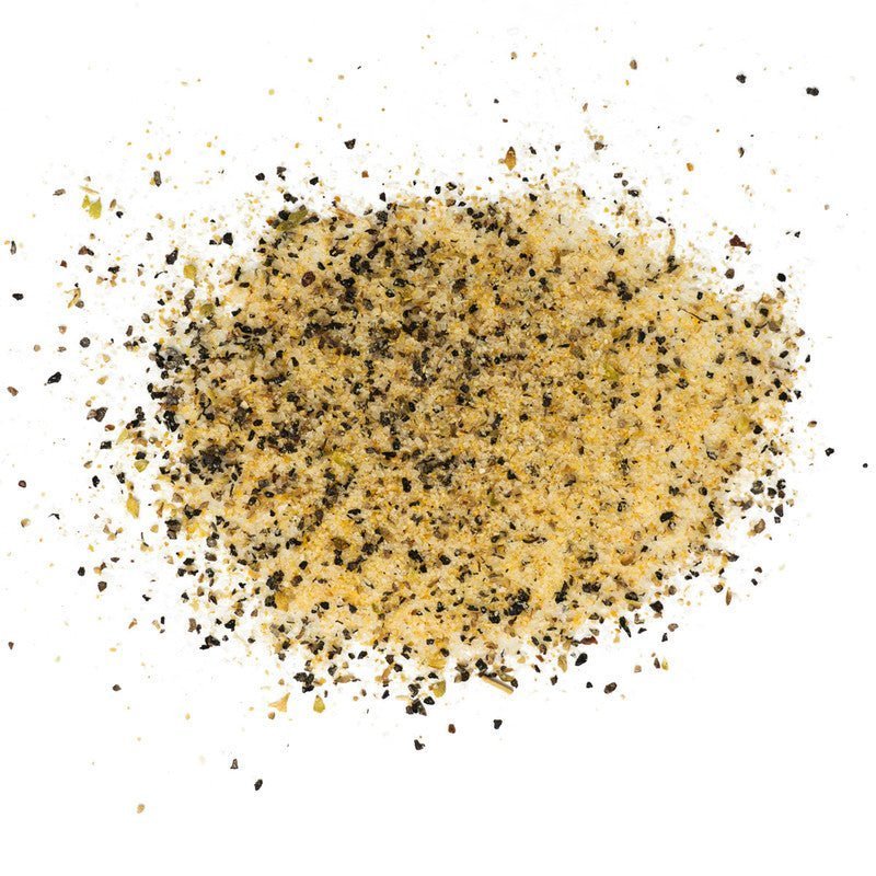 A close-up view of a scattered mixture of Rio Valley Meat Blanco AP Rub seasoning, showing a blend of coarse black pepper, salt, and other spices.