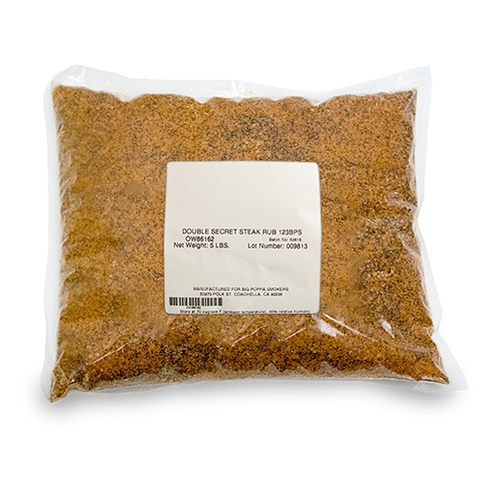 Packaged clear plastic bag filled with a fine, reddish-brown seasoning labeled as 'Double Secret Steak Rub,' showing a net weight of 5 lbs.