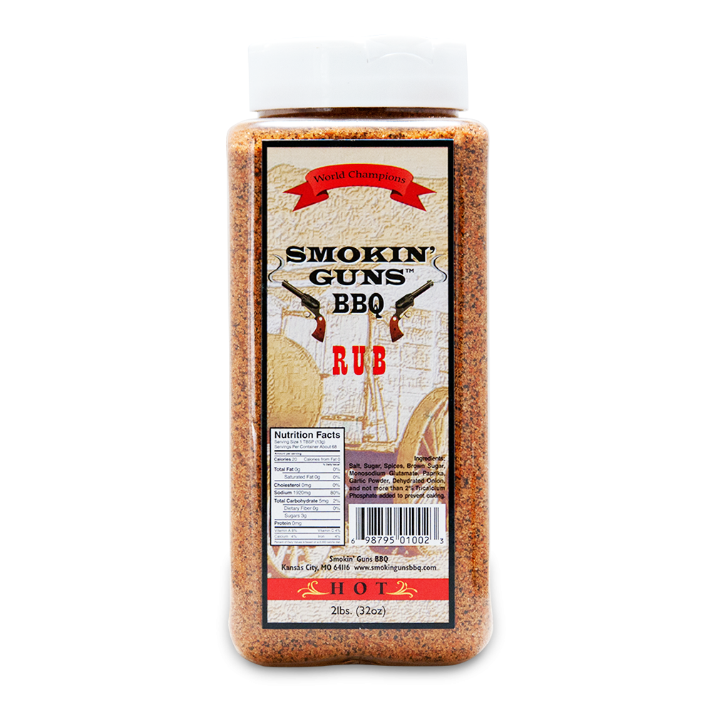 Close-up of a bottle of Smokin' Guns BBQ Rub with a vibrant label, showcasing the product's bold and smoky flavors. The bottle is set against a rustic wooden background, emphasizing its robust and savory seasoning perfect for grilling and BBQ dishes.
