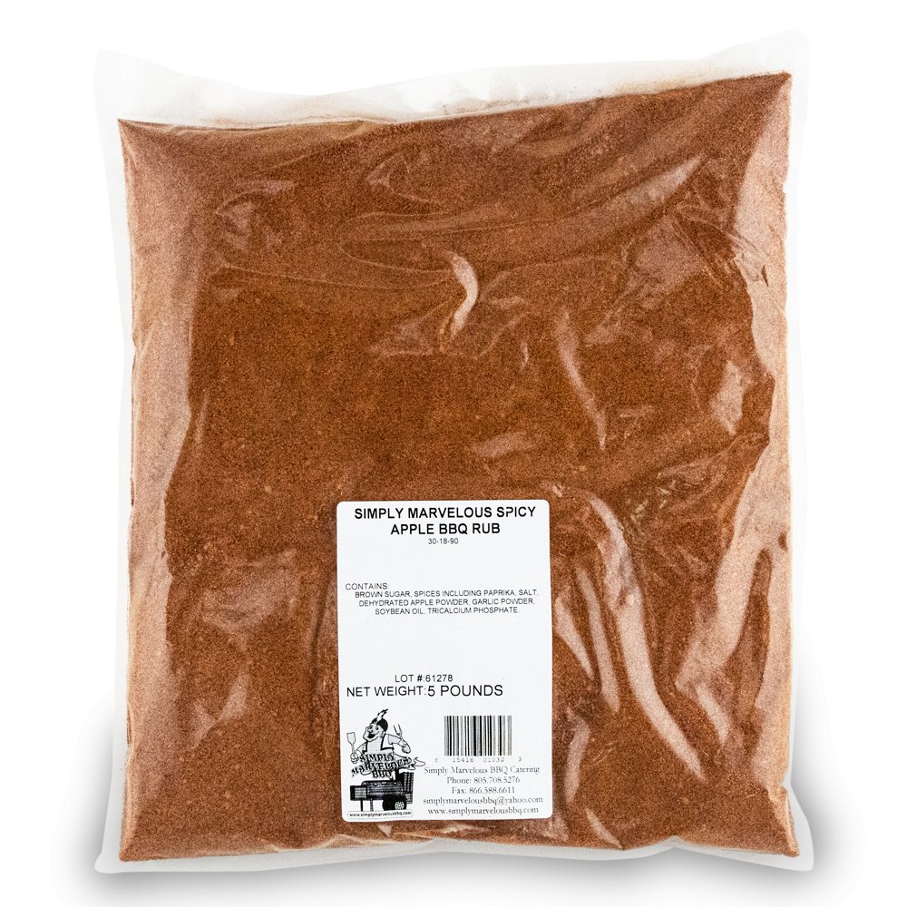 A large, clear plastic bag filled with a reddish-brown seasoning labeled 'Simply Marvelous Spicy Apple BBQ Rub.' The label lists ingredients including brown sugar, paprika, salt, dehydrated apple powder, garlic powder, and soybean oil. The net weight is 5 pounds. The label also features a barcode and the Simply Marvelous BBQ & Catering contact information.