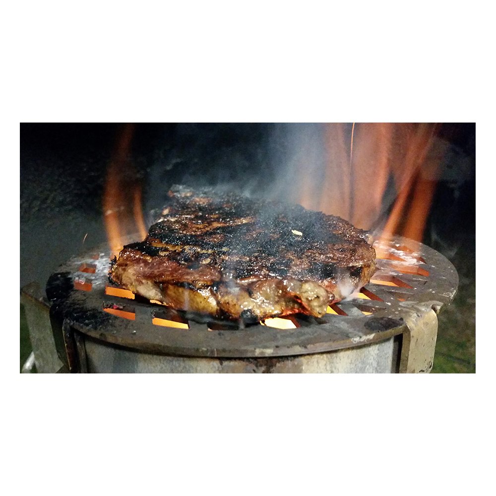 Unknown BBQ Chimney Griller, stainless steel accessory designed for grilling over a charcoal chimney, perfect for adding sear marks and enhancing BBQ flavor.  This is showing the griller with a steak on top of it cooking.